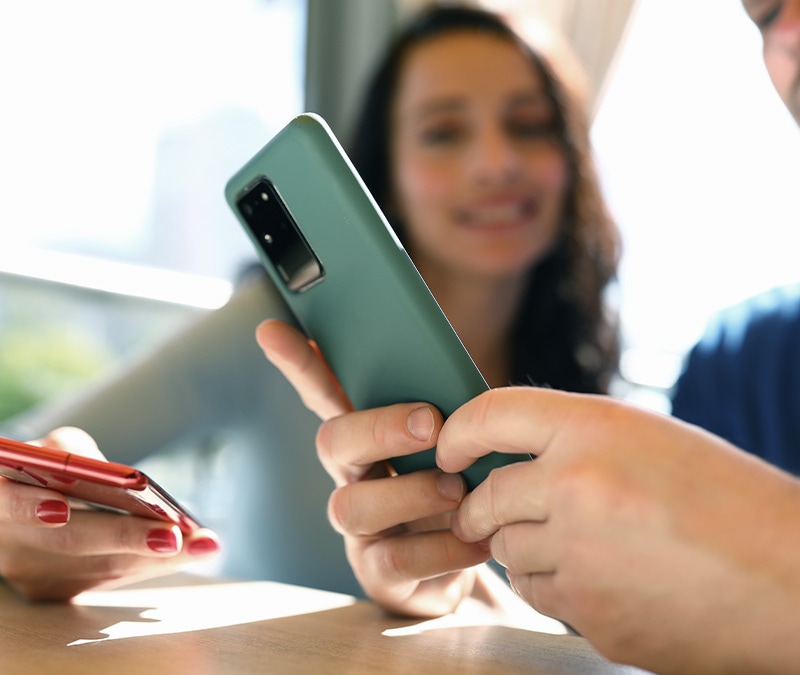Someone holding their device, trying to figure out how to detect spyware on their Android phone.